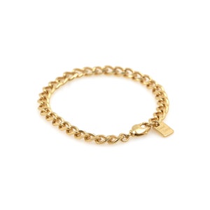May include: A gold chain bracelet with a small tag that says "Good Luck".
