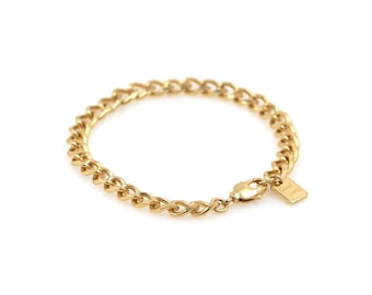 May include: A gold chain bracelet with a small tag that says "Good Luck".