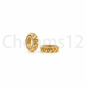 May include: Two gold-colored metal rings with a textured tire tread design. The rings are about 1 inch in diameter.