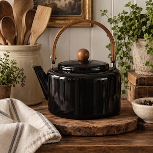 May include: A glossy black tea kettle with a cylindrical body, a matching lid featuring a round wooden knob, and a curved wooden handle attached with metal hardware. The kettle has a short, angled spout and a smooth, reflective finish.