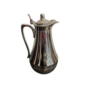 May include: A silver-colored, fluted pitcher with a handle and a lid. The pitcher has a bulbous base and a spout. The handle is curved, and the lid has a small knob. The pitcher is reflective, and the surface appears to be polished.
