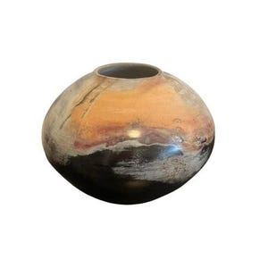 Puede incluir: Un jarrón de cerámica redondo y hecho a mano con una abertura ancha. El jarrón presenta una paleta de colores naranja, negro y blanco, con una superficie texturizada. El diseño es orgánico y abstracto, adecuado para la decoración del hogar.