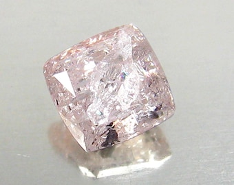 May include: A pale pink gemstone with a cushion cut and a slightly cloudy appearance.