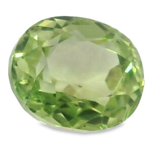 May include: A faceted, oval-cut peridot gemstone. The gem is a vibrant, light green color with a brilliant, reflective surface. The gemstone is set against a white background.