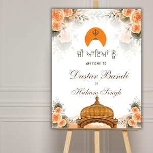 May include: A white welcome sign with orange floral borders and a golden turban symbol. The text reads "Welcome to Dastar Bandi of Hukam Singh" in English and Punjabi.