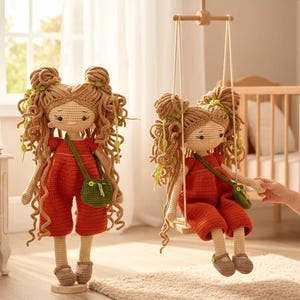 May include: Two handmade crochet dolls with long curly light brown hair styled in two buns. Each doll wears a red jumpsuit, a small green crossbody bag, and brown shoes. One doll stands on a circular base, while the other sits on a wooden swing.