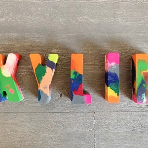 May include: The name "KYLIE" spelled out in colorful, multi-colored crayon letters.