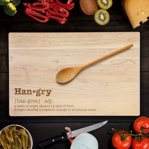 Op de afbeelding: Een houten snijplank met het woord "Han-gry" gedefinieerd als "een toestand van woede veroorzaakt door een gebrek aan voedsel; honger die een negatieve verandering in de emotionele toestand veroorzaakt."