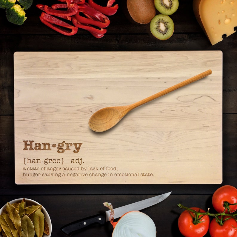Op de afbeelding: Een houten snijplank met het woord "Han-gry" gedefinieerd als "een toestand van woede veroorzaakt door een gebrek aan voedsel; honger die een negatieve verandering in de emotionele toestand veroorzaakt."