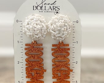 May include: Orange glitter "Hook 'Em Horns" earrings with white beaded dangles. The earrings are approximately 3 inches long.