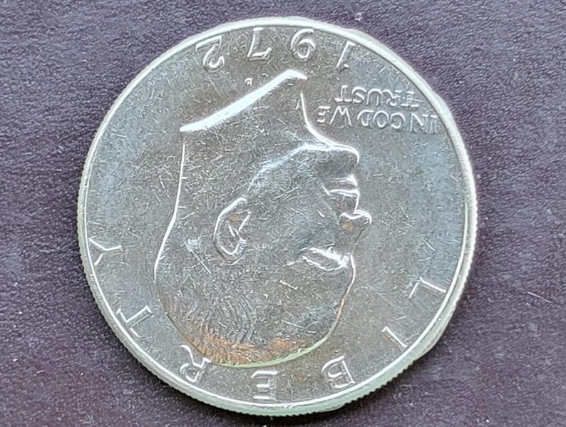 Op de afbeelding: Een zilveren 1972 Kennedy half dollar munt. De munt toont een profiel van John F. Kennedy en de woorden "LIBERTY" en "IN GOD WE TRUST". Het jaartal "1972" is zichtbaar aan de bovenkant.