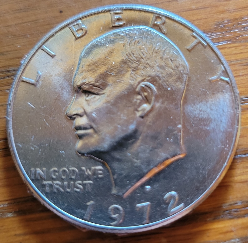 Op de afbeelding: Een zilveren 1972 Eisenhower dollar munt. De munt toont een profiel van president Dwight D. Eisenhower, met de woorden "LIBERTY" en "IN GOD WE TRUST". Het jaartal "1972" is ook zichtbaar.