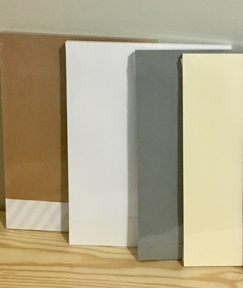 May include: Four different coloured pieces of cardstock, from left to right: brown, white, grey, and yellow.