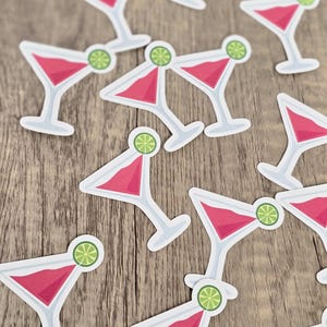 Pode incluir: Um conjunto de adesivos de coquetel rosa e branco com uma fatia de limão em cada um. Os adesivos são perfeitos para adicionar um toque festivo a qualquer festa ou evento.