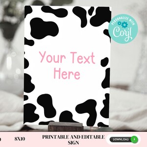 May include: Printable sign with a black and white cow print background. The text "Your Text Here" is written in pink on the sign. The sign is 5x10 inches and is printable and editable.
