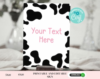 May include: Printable sign with a black and white cow print background. The text "Your Text Here" is written in pink on the sign. The sign is 5x10 inches and is printable and editable.
