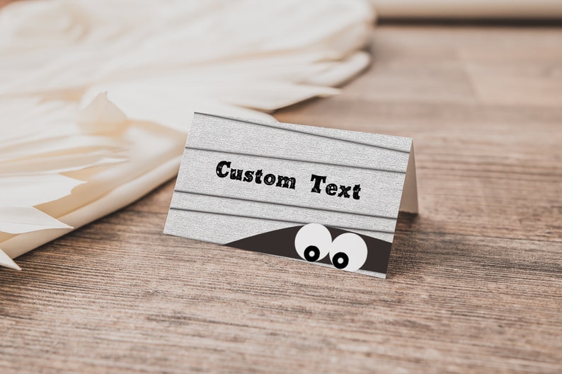May include: A white card with a woodgrain texture and the text "Custom Text" printed in black. Two white eyes peek out from behind a brown shape at the bottom of the card.