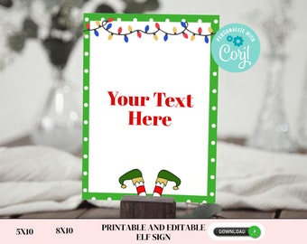 May include: Printable Christmas elf sign with a green background and white polka dots. The sign has a string of colourful lights at the top and says "Your Text Here".