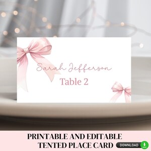 May include: Printable pink and white place card with a pink bow and the text "Sarah Jefferson Table 2".