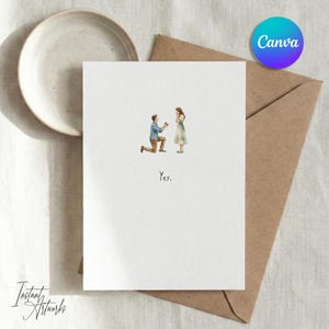 May include: A white card with a watercolor illustration of a proposal scene. A man kneels before a woman, with the word "Yes" below. The card is next to a brown envelope and a ceramic plate.