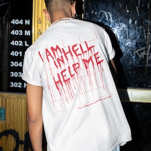 Peut inclure: T-shirt blanc avec du texte rouge qui coule et qui dit "I am hell help me" et une citation en dessous qui dit "Your suffering will be legendary, even in hell!"