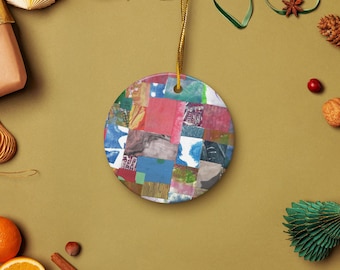 May include: A circular ceramic ornament featuring a patchwork design in shades of red, blue, and green. It has a gold hanging string. The background includes oranges, spices, and decorative elements.