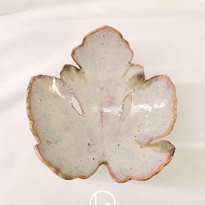 May include: A white ceramic mug with a black handle and the text "But First, Coffee" in a black, bold font. The mug is sitting on a wooden surface. The mug is 4 inches tall.