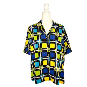 May include: A short-sleeved button-up shirt with a geometric pattern in shades of blue, yellow, green, and black.