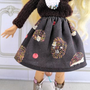 Puede incluir: Una falda negra con estampado de erizos y manzanas rojas. La falda est&aacute; hecha de una tela suave y c&oacute;moda y tiene una cintura el&aacute;stica.