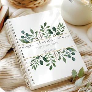 May include: A white spiral bound journal with a gold and green floral design. The text "Any Words Here" is written on the cover with the words "Your words can be added here" below it.