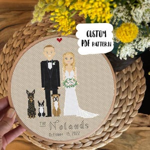 May include: A custom cross-stitch PDF pattern in a wooden hoop. The design features a bride and groom with three dogs, a red heart, and the text "The Nolands October 15, 2022". The text "CUSTOM PDF PATTERN" is also visible.