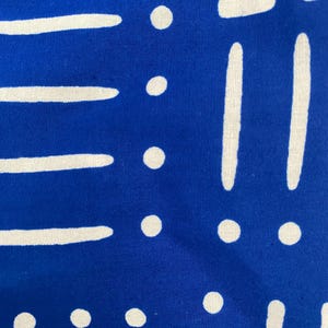 May include: Blue fabric with a white geometric pattern. The pattern includes circles, lines, and abstract shapes.