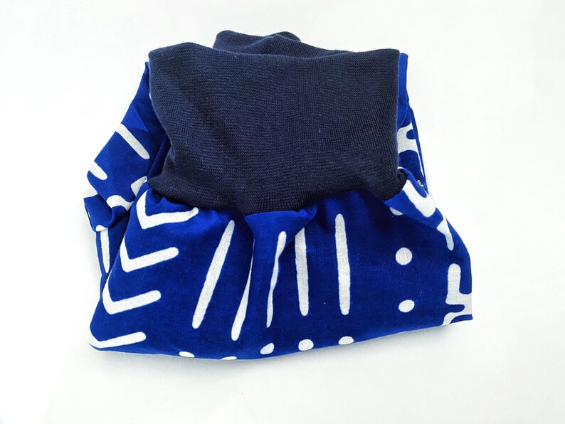 May include: Blue and white patterned fabric with a navy blue fold-over waistband. The fabric has a geometric pattern of white lines and dots on a blue background.