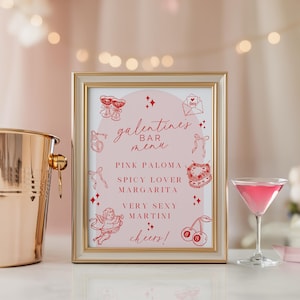 Puede incluir: Un "Menú de Bar de San Valentín" enmarcado con un marco dorado, con texto e ilustraciones rosas. El menú enumera cócteles como Pink Paloma y Very Sexy Martini. También se ve un cubo de hielo de cobre y una copa de cóctel rosa.