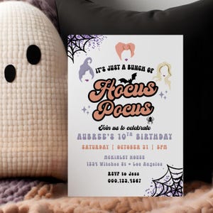 Könnte beinhalten: Eine weiße Einladungskarte mit dem Text "It's Just a Bunch of Hocus Pocus" in Orange und Schwarz. Die Einladung ist für Aubrees 10. Geburtstag, mit Datum, Uhrzeit und Ort. Die Karte hat ein Halloween-Thema.