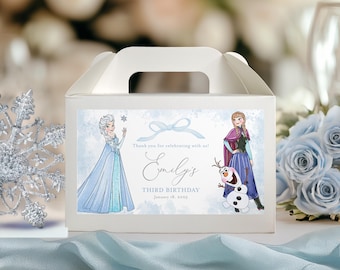 May include: White favor box with a blue and white design featuring Elsa and Olaf from the movie Frozen. The box has a handle and says "Thank you for celebrating with us! Emily's Third Birthday January 18, 2023".