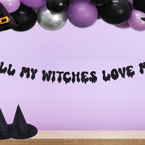 May include: Black and purple Halloween party decorations with a banner that reads "All My Witches Love Me".