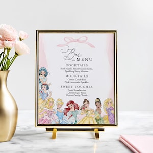 May include: A gold-framed bar menu with a pink watercolor background and the word "Bar Menu" in elegant script. The menu features cocktail and mocktail options, along with sweet treats. Disney princess illustrations adorn the bottom of the frame.