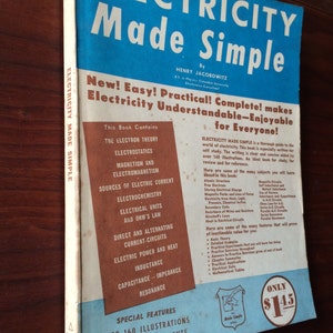 May include: A blue and white book cover with the title "Electricity Made Simple" and the author's name "Henry Jacobowitz". The cover features a list of topics covered in the book, including electron theory, electrostatics, magnetism, and sources of electric current. The book also includes over 160 illustrations and 25 basic experiments that can be done at home.