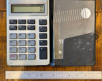 Vintage 1970’s Texas Instruments TI-1766 hand held solar calculator, cover is cracked and taped, has instructions – works!