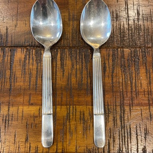 Two Vintage 1950’s Hotel silver side spoons stamped “W over M,” 60, a diamond and a hallmark - column  design measures 6” long