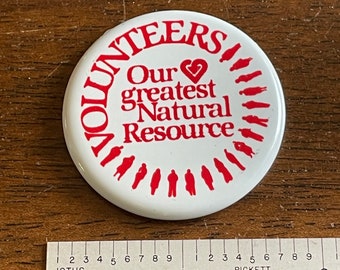 Vintage 1980s “Volunteers our greatest natural resource“ button in white with red writing - missing the pin on the back