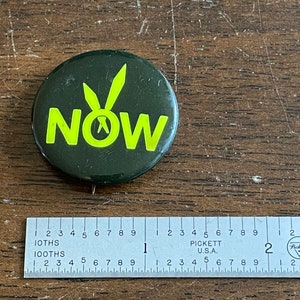 May include: A green button with a yellow peace sign and the word "NOW" in yellow letters.