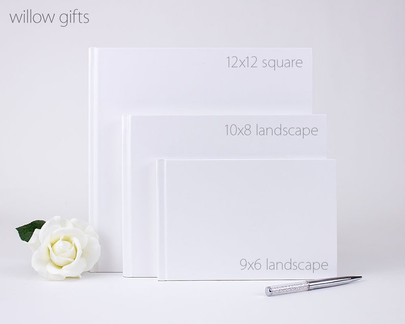 May include: Three white photo albums of different sizes. The largest album is 12x12 inches square, the middle album is 10x8 inches landscape, and the smallest album is 9x6 inches landscape.