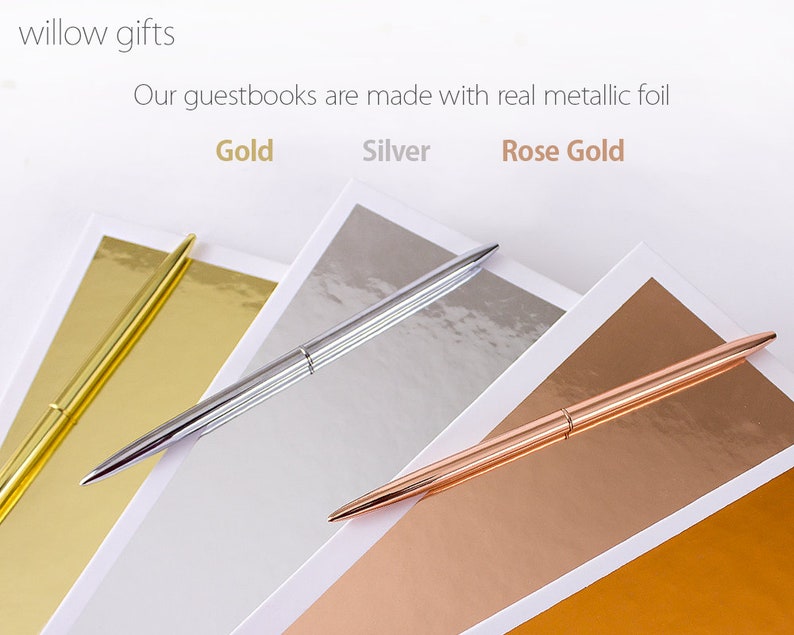 May include: Three pens with gold, silver, and rose gold finishes are laid on top of matching colored paper. The text "Our guestbooks are made with real metallic foil" is above the pens. The words "Gold", "Silver", and "Rose Gold" are written below the pens.