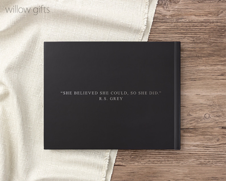 May include: Black hardcover journal with the quote "SHE BELIEVED SHE COULD, SO SHE DID." by R.S. GREY printed in white on the front cover.