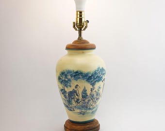 Lámpara de mesa de cerámica vintage grande, color crema y azul, con escena pastoral.
