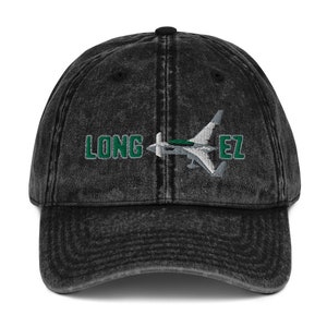 May include: Black vintage denim baseball cap with a white airplane and green text that reads "LONG EZ".