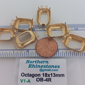 Puede incluir: Seis engastes de metal dorado para piedras de imitación de forma octogonal, que miden 18 mm por 13 mm. Los engastes tienen cuatro garras y dos bucles a cada lado. El texto "Octagon 18x13mm V1-A OB-4R" es visible en una etiqueta blanca.