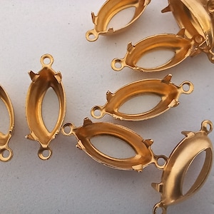 May include: Gold-toned metal oval-shaped pendant settings with three prongs on each side. The settings have a loop on the top for attaching a chain or cord.
